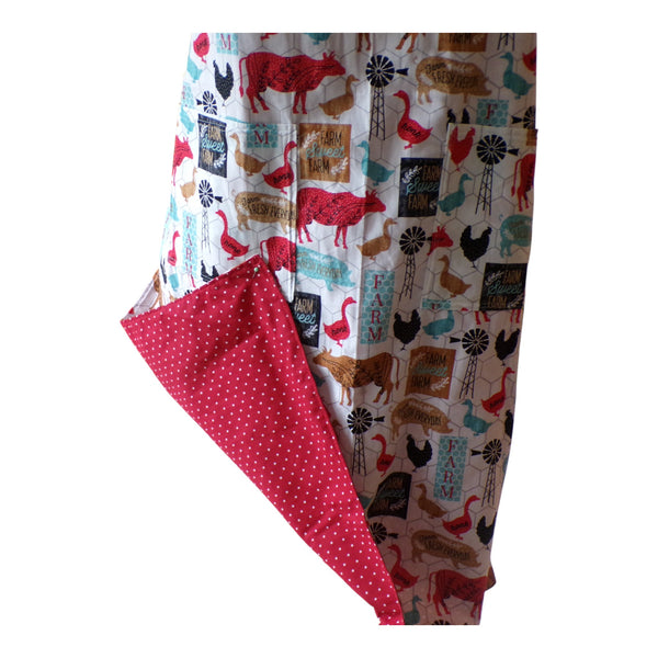 Apron with farm animal pattern on one side and red polka dot pattern on the reverse